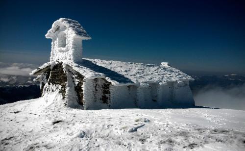 a building covered in snow on top of a mountain at Apartamentos Herri Ondo REFUGIO CLIMATICO in Iturmendi