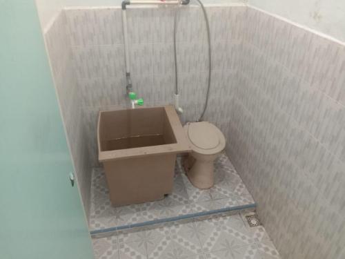 Un pequeño baño con inodoro y ducha. en Friendjoss Homestay Laugumba RedPartner, en Berastagi