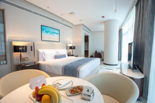 a hotel room with a bed and a table with food on it at Century Marina Hotel - Lusail in Lusail