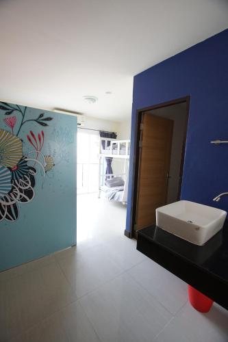 a bathroom with a sink and a blue wall at Bedbox Hostel in Patong Beach