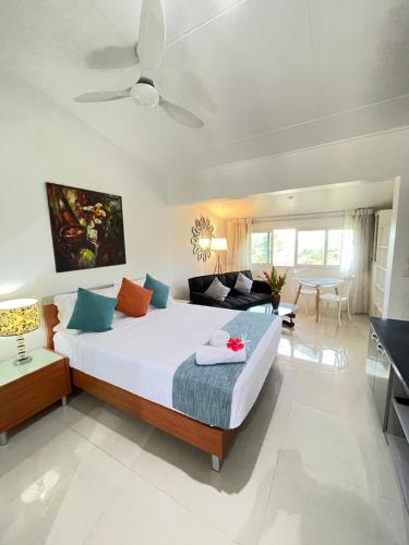 a bedroom with a large bed and a living room at Elluk East Studios in Port Vila