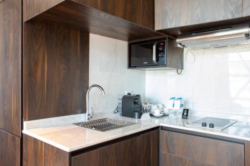 a kitchen with a sink and a microwave at Century Marina Hotel - Lusail in Lusail