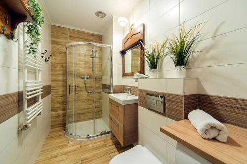 La salle de bains est pourvue d'une douche, de toilettes et d'un lavabo. dans l'établissement Trevilles Apartamenty - Orzechowy, à Szklarska Poręba
