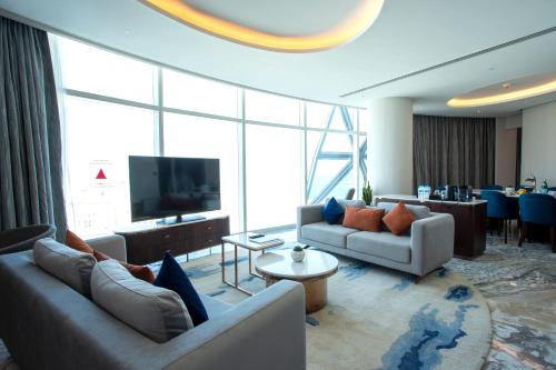 a living room with two couches and a television at Century Marina Hotel - Lusail in Lusail