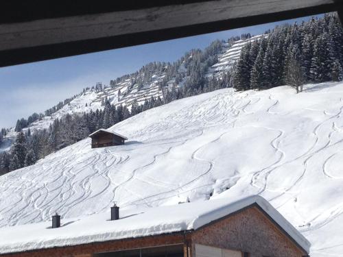 a mountain covered in snow with a building at Gästehaus Fritz in Mittelberg