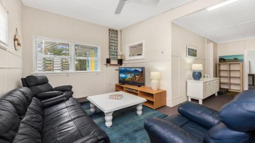a living room with a leather couch and a table at 92 Landsborough Parade Golden Beach in Golden Beach