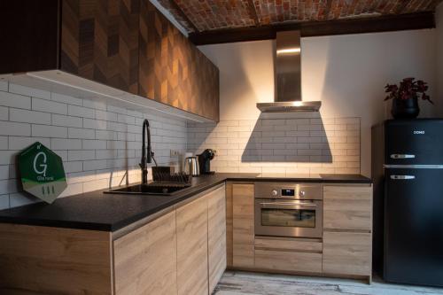 a kitchen with a black refrigerator and a stove at Le Relais de la Posterie in Gembloux