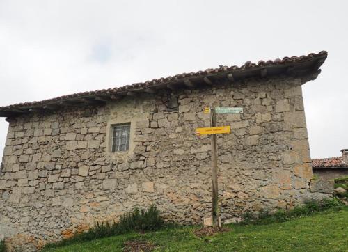 a stone building with a street sign in front of it at Apartamentos Herri Ondo REFUGIO CLIMATICO in Iturmendi