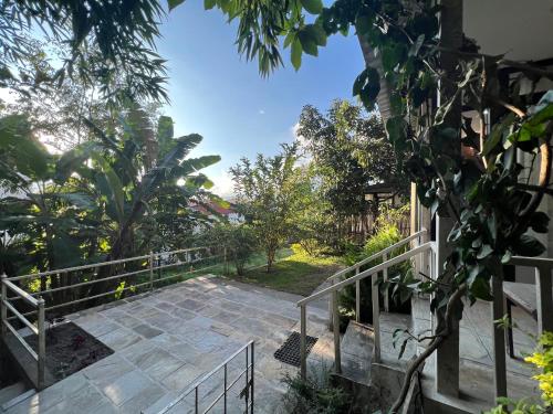 a staircase leading up to a house with trees at Avocado Cottages in Khadkagaon