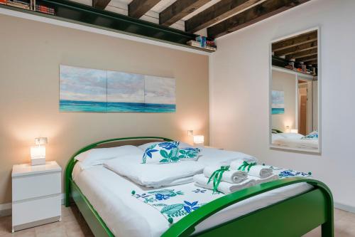 a bedroom with a green and white bed and a mirror at Iseo Portelle Holiday with private parking in Iseo