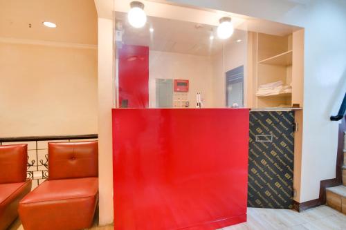 um balcão vermelho num restaurante com duas cadeiras laranja em OYO 912 Fb Suites 