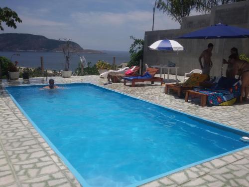 尼泰羅伊的住宿－米蘭特貝拉維斯塔民宿，在蓝色游泳池游泳的人