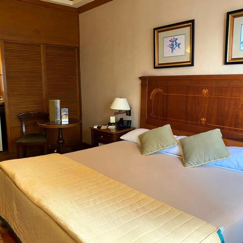 a bedroom with a large bed with a wooden headboard at Herald Suites in Manila