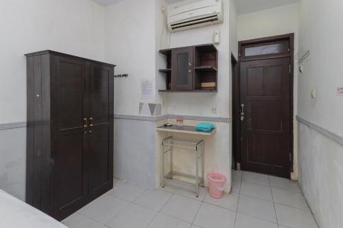 cocina con 2 armarios marrones y lavamanos en RedDoorz near Stasiun Malang Kota Lama 2, en Malang