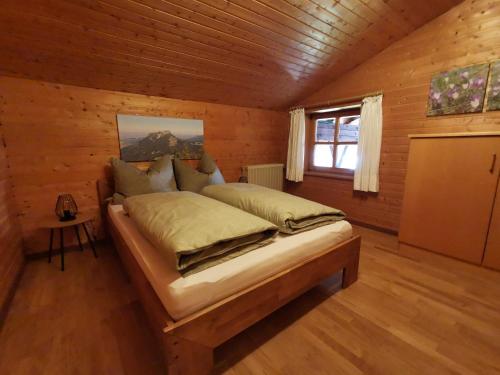 a bedroom with a bed in a log cabin at Ferienhaus Luise in Samerberg