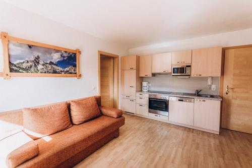 a living room with a couch and a kitchen at Grassbichlhof in Altenmarkt im Pongau