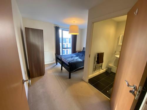 a room with a bedroom with a bed and a mirror at Rooms in exquisite and centrally located apartment in Colindale