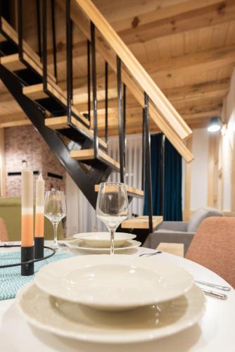 a table with a plate and wine glasses on it at Mila house Tara in Bajina Bašta