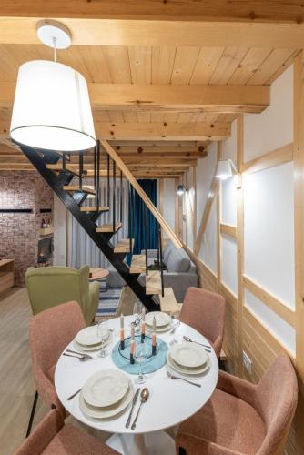 a dining room with a table and chairs and a staircase at Mila house Tara in Bajina Bašta