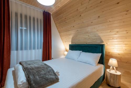 a bedroom with a bed with a wooden wall at Mila house Tara in Bajina Bašta