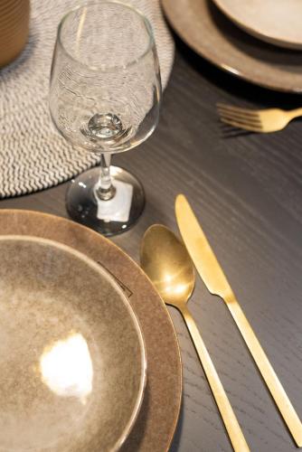 a table with plates and a wine glass and silverware at Mila house Tara in Bajina Bašta