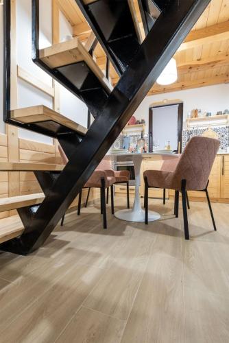 a room with a staircase with chairs and a table at Mila house Tara in Bajina Bašta
