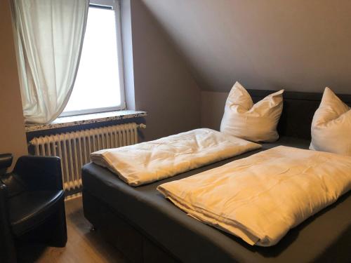 a bed with two pillows on it in a room at Geräumiges Haus mit viel Platz, Garten und den Parkplätzen in Jübek