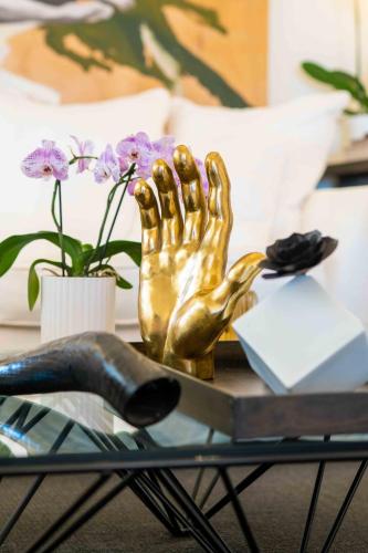 a glass table with a gold hand statue on it at CasaVostra - Ambience Suites in Ostra Vetere
