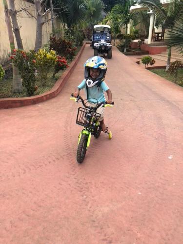 a young child riding a bike on a dirt road at Villa Soa in Hell-Ville