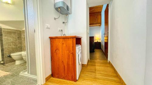 a hallway of a bathroom with a sink and a toilet at Appartamento Frejus - Affitti Bevi Italia in Bardonecchia