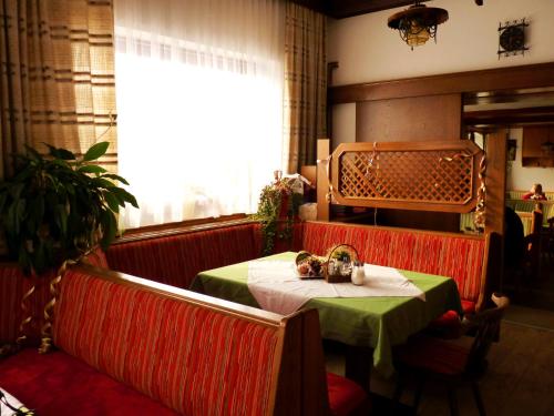 ザンクト・ファイト・アン・デア・グランにあるGasthof Kaiserの緑のテーブルクロスを敷いたレストランのテーブル