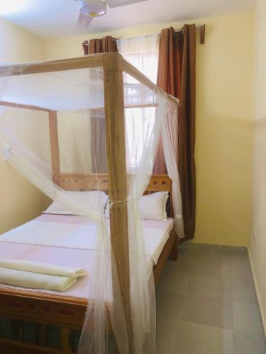 2 łóżka piętrowe w pokoju z oknem w obiekcie Mtwapa Apartment w mieście Mombasa