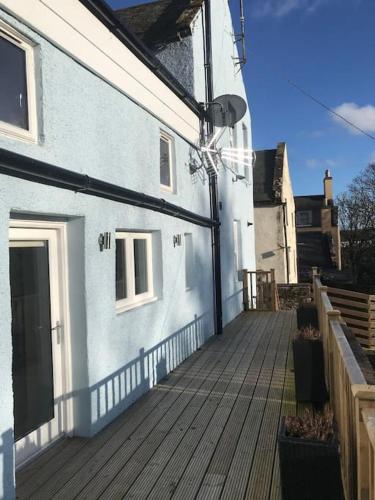 a house with a wooden deck next to a building at Brechin Townhouse - Cathedral View in Brechin