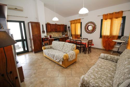 una sala de estar con un sofá y una mesa en Casa di Fabia, en SantʼAntìoco