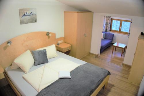 a bedroom with a large bed and a living room at Stallhäusl in Schladming