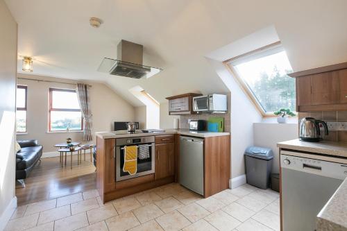 a kitchen with a stove top oven next to a living room at Tollyrose Loft apartment in Newcastle