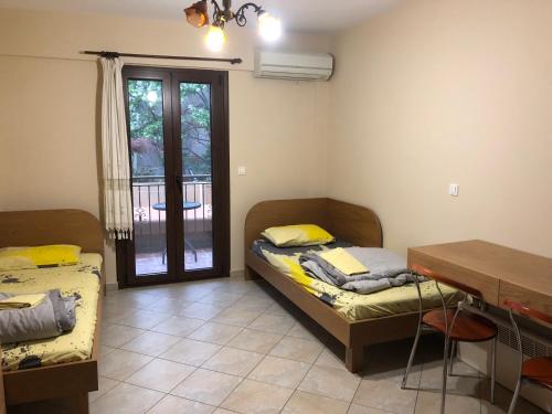 two beds in a room with a table and a desk at Studios Arabas in Thessaloniki
