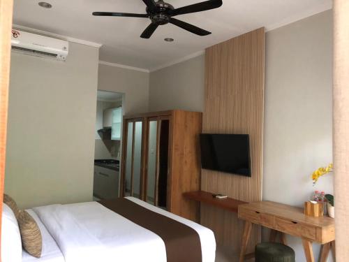 una camera con letto e ventilatore a soffitto di Dewi Dewi Villas a Sanur