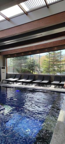 a swimming pool with chairs in a building at St Ivan Rilski Spa Luxury apartment Bansko & Free SPA in Bansko