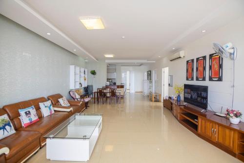 Son Thinh Apartment في فنغ تاو: غرفة معيشة كبيرة مع كنب وتلفزيون