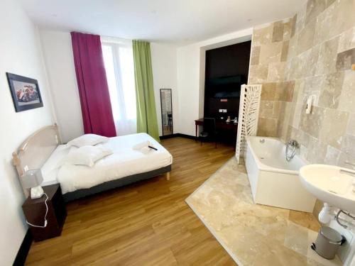 a bedroom with a bed and a tub and a sink at Enzo Hotels Limoges Centre Jourdan by Kyriad Direct in Limoges