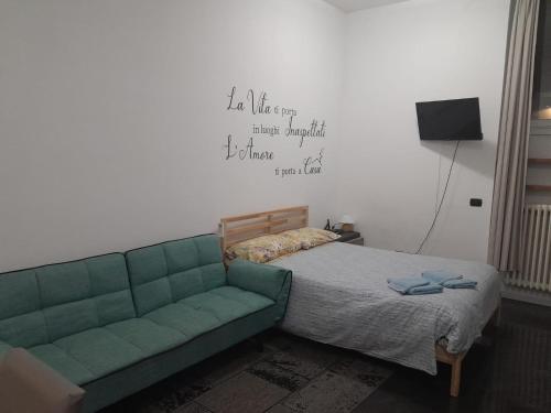 sypialnia z zieloną kanapą i łóżkiem w obiekcie Affitti brevi Caterina 2 w mieście Sesto San Giovanni