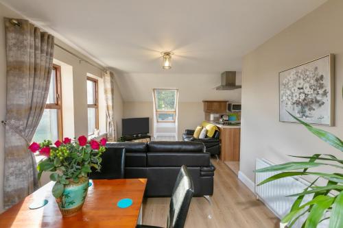 a living room with a couch and a table at Tollyrose Loft apartment in Newcastle