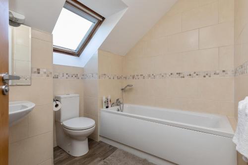 a bathroom with a toilet and a bath tub at Tollyrose Loft apartment in Newcastle