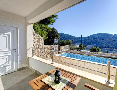 a patio with a table and a swimming pool at Villa Katarina Dubrovnik in Dubrovnik