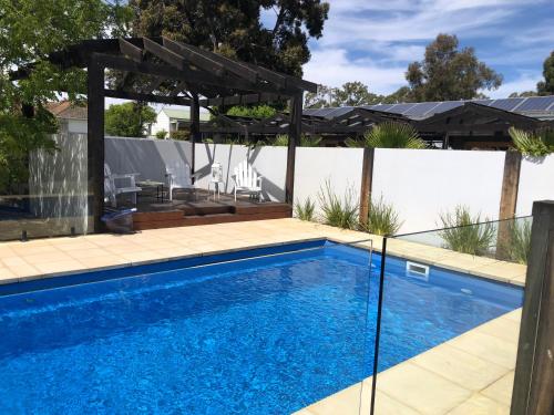 a swimming pool with a pergola next to a house at Happy Wanderer Motel Bendigo CHILDREN NOT PERMITTED over 18s only in Bendigo