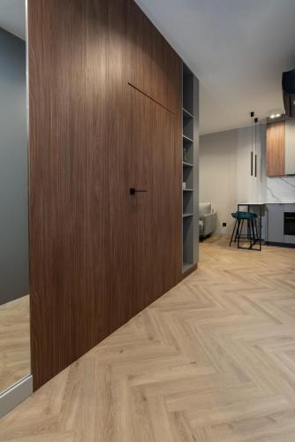 a large wooden door in a room with a kitchen at Apartamenty Olimpijska by RENT4YOU in Olsztyn