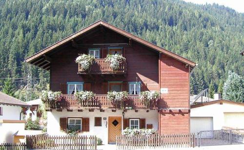 a house with potted plants on the balcony of it at Arlberghaus Rocks in Flirsch