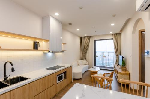 a kitchen with a sink and a living room at Ecopark - Lullaby Home Ecopark in HÆ°ng YÃªn
