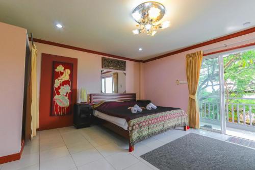 a bedroom with a bed and a large window at The Phen House in Hua Hin